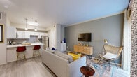 Located at 12500 Merit Dr in Dallas, TX, this thoughtfully designed one-bedroom, one-bathroom residence offers an efficient and stylish single-floor layout. The open-concept living and kitchen area forms the heart of the home, where light wood-look flooring, crown molding, and neutral tones create a bright, cohesive atmosphere. The kitchen is outfitted with white shaker cabinetry, a grey subway tile backsplash, stainless steel appliances, a white quartz peninsula with bar seating, and pendant lighting — combining functionality with modern aesthetics. The living area flows seamlessly from the kitchen, featuring a large sliding glass door that invites natural light and connects to the outdoors. The bedroom is a comfortable retreat with a ceiling fan, large windows, and generous natural light. Four closets throughout the unit provide notable storage capacity, including a spacious walk-in closet with multi-tier wire shelving. The full bathroom features an extended vanity with ample cabinet storage, a large mirror, and a shower/tub combination. A dedicated in-unit laundry room with side-by-side washer and dryer hookups adds everyday convenience. Wood-look flooring runs throughout, tying the entire space together with a clean, contemporary feel.