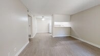 Located at 1498 Brookside Ave in Redlands, CA, this single-floor, one-bedroom, one-bathroom unit offers a functional and well-organized layout. The open-concept living and kitchen area is finished with durable wood-look vinyl flooring and neutral beige tones throughout, creating a clean, cohesive aesthetic. A ceiling fan anchors the living area, which flows naturally into the kitchen via a pass-through counter with a built-in sink — ideal for both everyday living and casual entertaining. The galley-style kitchen features white shaker cabinetry, a gas range, refrigerator, and light-colored countertops, all illuminated by recessed lighting. A hallway with a built-in white cabinet provides additional storage and leads to the private bedroom. The bedroom is carpeted for comfort and includes a ceiling fan, a window that brings in natural light and views of surrounding greenery, and access to a dedicated walk-in closet with built-in shelving and hanging rods. The bathroom is conveniently positioned off the hallway. Throughout the unit, textured ceilings, crisp white trim, and consistent neutral finishes contribute to a tidy, move-in-ready atmosphere well-suited for comfortable single-occupant living.
