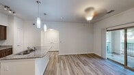 This contemporary 1-bedroom apartment in Austin, TX, maximizes its 580 square feet with an efficient and stylish design. The heart of the home is a sleek, open-concept kitchen featuring dark wood cabinetry, stainless steel appliances, and granite countertops. A central island with a sink provides additional workspace and casual dining options.

The spacious bedroom, measuring 140 square feet, is adorned with a decorative ceiling fan and large windows that flood the space with natural light. Durable wood-look flooring runs throughout the apartment, creating a cohesive and modern aesthetic. The bathroom continues the apartment's elegant theme with a granite-topped vanity, wood cabinetry, and a shower/tub combination with white tile surround.

The unit's layout includes a hallway and closet space for added storage and functionality. Large windows in the living area offer views of the surrounding landscape and fill the space with natural light. The apartment's neutral color palette and clean lines create a versatile canvas for various decorating styles, making it an ideal space for comfortable, contemporary living in Austin.