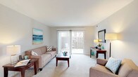 Located in Dublin, Ohio, this single-floor residence offers a thoughtfully designed layout with a clean, neutral aesthetic throughout. The spacious living room is a central highlight, featuring plush carpeting, large sliding glass doors that open to a private outdoor patio, and an abundance of natural light that creates an open, airy atmosphere. The living area flows naturally into the dining space, which includes a large window overlooking greenery and convenient access to a walk-in closet.

The kitchen is well-equipped with ample white cabinetry, dark countertops, black appliances including a range and over-the-range microwave, and tile flooring that adds a practical, easy-to-maintain surface. Both bedrooms are comfortably sized with soft carpeting, natural light from well-placed windows, and closet storage. The primary bedroom features a walk-in closet and room for a full furniture arrangement. The bathroom offers a tub-shower combination, tile flooring, and a bright window that brings in natural light. Throughout the home, a consistent neutral color palette and carpet contribute to a calm, cohesive living environment.