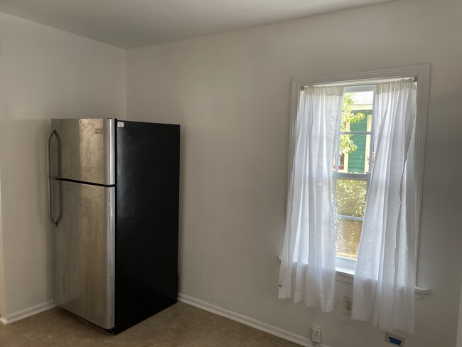 Refrigerator and dining area. - 1230 Mandeville St