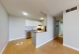 Located at 10127 121 Street NW in Edmonton, Alberta, this well-appointed three-bedroom, one-bathroom unit offers a practical and comfortable layout across a single floor. Light-toned hardwood flooring runs throughout the main living areas and bedrooms, creating a warm, cohesive feel. Neutral grey walls provide a clean, modern backdrop throughout the space.

The galley-style kitchen is efficiently designed with sleek white cabinetry, grey countertops, a white tile backsplash, and a full suite of stainless steel appliances including a refrigerator, dishwasher, and electric range. An adjacent closet offers additional storage convenience. The kitchen opens toward the living room, which benefits from natural light and a straightforward, open layout ideal for everyday living.

Each of the three bedrooms features the same warm hardwood flooring and neutral tones. The bedrooms are well-sized, with the primary bedroom offering a generous footprint. Two of the bedrooms are equipped with sliding-door closets, maximizing storage. Large sliding windows in the bedrooms frame views of the Edmonton skyline, filling the rooms with natural light.

The bathroom is finished with white ceramic floor tiles, full white subway tile surround around the tub-shower combination, and a wall mirror. The overall design of the unit is clean, functional, and move-in ready.