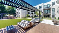 Located at 169 Johnson Rd in Morris Plains, New Jersey, this contemporary residential property presents a striking courtyard-centered design that blends modern architecture with thoughtfully curated outdoor living. The building's exterior features a clean, multi-story façade finished in light grey paneling and siding, accented by bold dark-framed windows and private balconies that overlook the central courtyard below.

At the heart of the property lies an expansive, well-maintained green lawn that serves as the focal point of the outdoor space. Surrounding the lawn, a series of raised planters filled with ornamental grasses and shrubs provide structured, year-round landscaping that adds texture and color throughout.

A standout feature of the courtyard is a sleek pergola structure outfitted with string lights and comfortable outdoor seating, creating an inviting lounge area ideal for relaxation and social gatherings. Additional seating areas with market umbrellas are positioned throughout the patio, offering shaded retreats under open skies.

The layout of the courtyard, as visible from an aerial perspective, reveals a thoughtfully enclosed design where the building wraps around the green space, ensuring residents enjoy both privacy and a sense of community. The overall ambiance is one of refined, resort-style outdoor living in a well-appointed suburban New Jersey setting.