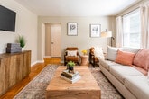 Located at 178 Hollywood Ave in Irvington, NJ, this single-floor residence offers a well-organized layout with a cohesive, neutral aesthetic throughout. The living room serves as the heart of the space, featuring warm hardwood parquet flooring and multiple windows that allow generous natural light to fill the room. Soft, neutral wall tones complement the inviting atmosphere, creating a comfortable and versatile setting.

The kitchen is efficiently designed, showcasing light honey-toned wood cabinetry with open shelving above, granite-patterned countertops, a stainless steel sink, and a full-size stainless steel refrigerator. Light tile flooring completes the clean, functional look of the kitchen area.

The bedroom continues the warm parquet flooring found throughout the unit and includes a window with natural views, providing ample light and ventilation. Closet access and space for a dedicated workspace make it a practical and comfortable room.

The bathroom is finished with large-format sandy beige wall tiles surrounding a soaking tub and shower combination, complemented by white cabinetry, light floor tiles, and a frosted window that adds privacy while maintaining brightness. Overall, the space presents a clean, well-maintained interior with consistent finishes throughout.