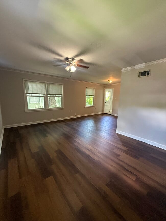 Spacious open-concept living area with brand-new flooring, abundant natural light, and plenty of roo - 823 Rittiner Dr