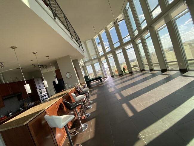 living room with the 12 ft wrap-around windows and private balcony overseeing the city - 100 N Santa Rosa St