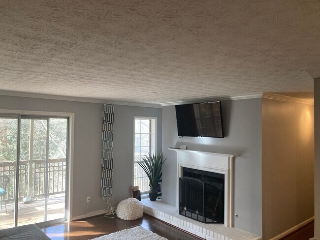 Amplia sala de estar con chimenea y magníficas vistas al arroyo. - 2901 Lenox Rd NE