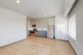 Located at 2065 S Cherokee St in Denver, CO, this single-floor, 2-bedroom, 2-bathroom residence offers a well-designed layout with modern finishes throughout. The open-concept living, dining, and kitchen area forms the heart of the unit, featuring light wood-style luxury vinyl flooring and recessed lighting. The kitchen is outfitted with stainless steel appliances — including a range, microwave, and dishwasher — complemented by two-tone cabinetry with white upper cabinets and gray lower cabinets, a subway tile backsplash, and a undermount sink. A large window in the living area provides natural light and views of the Denver skyline. Both bedrooms are carpeted, each with ceiling fans and ample closet space featuring paneled double doors. The spacious primary bedroom offers a tray ceiling detail and natural light from a window with blinds. Both bathrooms are finished consistently, with white subway tile tub-and-shower surrounds, wood-style flooring, and dark-toned vanities. Additional features include a dedicated laundry area, three closets for generous storage, and an entrance hallway. The unit reflects a clean, contemporary aesthetic with a neutral color palette throughout.