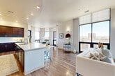 Located at 3465 S Gaylord Ct in Englewood, Colorado, this sophisticated single-floor residence offers 2 bedrooms and 4 bathrooms across a generously proportioned open layout. The interior is defined by soaring floor-to-ceiling windows that flood every room with natural light and frame sweeping views of the city skyline and the Rocky Mountains beyond.

The open-concept living, dining, and kitchen area serves as the heart of the home. The gourmet kitchen is outfitted with rich dark wood cabinetry, a white quartz waterfall island with bar seating, a tile backsplash, and stainless steel appliances. The living room features a fireplace and an expansive wall of windows, creating a bright and inviting atmosphere. The dedicated dining area flows seamlessly between the kitchen and living spaces.

The spacious primary bedroom enjoys its own large window wall with panoramic views, while the secondary bedroom doubles effectively as a private office or guest suite with equally impressive floor-to-ceiling glazing. Four well-appointed bathrooms feature tile flooring, dark wood vanities, and walk-in showers. Additional highlights include four closets, a dedicated laundry room with full-size washer and dryer, and hardwood flooring throughout the main living areas.