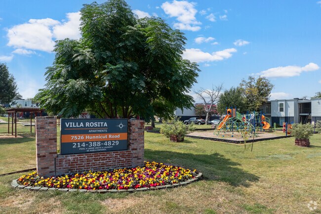 Monumento Comunitario con Flores – Letrero de Villa Rosita rodeado de coloridos jardines de temporada. - Villa Rosita Apartments
