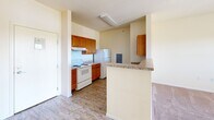 Located at 1035 S Main St in Decatur, Illinois, this one-bedroom, one-bathroom unit offers a practical and well-organized single-floor layout. The galley-style kitchen is a functional highlight, featuring warm oak cabinetry, granite-look countertops, wood-look flooring, a coil-top electric range, and a full-size refrigerator. A peninsula counter extends from the kitchen, providing additional prep space and a natural boundary between the kitchen and the living area. The bedroom is a comfortable and well-lit space, outfitted with plush carpeting, a ceiling fan with light fixture, a baseboard heater, and a window that invites natural light and outdoor views. The bedroom is complemented by a dedicated walk-in closet with wrap-around wire shelving, offering generous storage options. The bathroom is neatly appointed with a wood-vanity featuring a granite-look countertop, a mirrored medicine cabinet, wood-look flooring, and a full-size soaking tub with shower. Warm neutral tones are carried throughout the unit, creating a cohesive and calm ambiance. The overall layout is efficient and thoughtfully designed, making excellent use of its compact footprint.