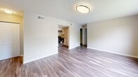 Located at 95 Willow Springs Rd in Lexington, Virginia, this single-floor unit offers a well-organized layout with a clean, neutral design that creates a welcoming and functional living environment. The open living area is finished with durable hardwood-style flooring and receives ample natural light through a large picture window that overlooks the surrounding greenery, giving the space an airy and bright feel. A textured ceiling and flush-mount lighting are consistent throughout, adding to the cohesive aesthetic. The living area connects directly to the kitchen, which is equipped with crisp white shaker-style cabinetry, granite-patterned countertops, a stainless steel sink with a pull-down faucet, and a black gas range. The layout provides generous counter and storage space for everyday use. The bedroom features soft wall-to-wall carpeting, a window with horizontal blinds for light control and privacy, and a walk-in closet offering practical storage. The bathroom is finished with hardwood-style flooring, a white vanity with under-cabinet storage, a framed mirror with overhead lighting, and a tub-shower combination. Throughout the unit, neutral wall tones and clean white trim contribute to a fresh, move-in-ready atmosphere.