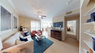 This single-floor residence showcases a thoughtfully designed open layout with a warm, coastal-inspired aesthetic carried throughout. The living room serves as the heart of the home, featuring crown molding, a ceiling fan, and light wood-style flooring. Large windows fitted with horizontal blinds allow natural light to fill the space, complementing the neutral beige walls. A dedicated dining area adjacent to the living space includes a generous window, enhancing the airy feel of the room.

The kitchen is well-equipped with dark espresso cabinetry, granite countertops, stainless steel appliances including a range and built-in microwave, and a stainless steel sink — offering both style and functionality.

Two bedrooms provide comfortable retreats, each with plush carpeting, ceiling fans, and ample natural light. Both rooms include closet storage, and one features a dedicated dresser area. The two bathrooms mirror the kitchen's design language, with granite-topped dark vanities, tub-shower combinations, and light wood-style flooring.

Throughout the residence, a cohesive coastal color palette of navy, coral, and cream ties the rooms together, creating a serene and inviting atmosphere.