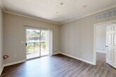 Located at 701 TC Jester Blvd in Houston, TX, this well-appointed one-bedroom, one-bathroom residence offers a smart, efficient layout across a single floor. The combined living and dining area serves as the heart of the home, featuring rich wood-style flooring, neutral gray walls, crown molding, and a sliding glass door that opens to a private balcony with outdoor views — filling the space with natural light. The kitchen is a standout feature, outfitted with crisp white cabinetry, gray subway tile backsplash, granite-look countertops, a peninsula with an undermount sink, stainless steel appliances including a refrigerator, range, and microwave, as well as durable wood-style flooring. The bedroom is a comfortable retreat with its own ceiling fan, large window with natural light, and access to generous closet space. The bathroom includes a full tub-shower combo with white tile surround and granite-accented vanity. A dedicated in-unit stacked washer and dryer adds everyday convenience. With three closets and a well-connected hallway layout, storage and flow are thoughtfully addressed throughout this compact yet functional Houston home.