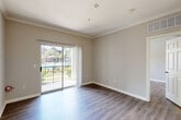 Located at 701 TC Jester Blvd in Houston, TX, this well-appointed one-bedroom, one-bathroom residence offers a smart, efficient layout across a single floor. The combined living and dining area serves as the heart of the home, featuring rich wood-style flooring, neutral gray walls, crown molding, and a sliding glass door that opens to a private balcony with outdoor views — filling the space with natural light. The kitchen is a standout feature, outfitted with crisp white cabinetry, gray subway tile backsplash, granite-look countertops, a peninsula with an undermount sink, stainless steel appliances including a refrigerator, range, and microwave, as well as durable wood-style flooring. The bedroom is a comfortable retreat with its own ceiling fan, large window with natural light, and access to generous closet space. The bathroom includes a full tub-shower combo with white tile surround and granite-accented vanity. A dedicated in-unit stacked washer and dryer adds everyday convenience. With three closets and a well-connected hallway layout, storage and flow are thoughtfully addressed throughout this compact yet functional Houston home.