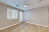 Located at 8165 W Whitney Dr in Peoria, AZ, this well-appointed single-story home offers 2 bedrooms and 2 bathrooms within a thoughtfully designed floor plan. Light wood-tone flooring flows consistently throughout, complementing the neutral gray and white palette found in every room.

The kitchen is a standout feature, showcasing warm wood cabinetry, crisp white quartz countertops, a subway tile backsplash, stainless steel appliances including a refrigerator with ice maker, and a central island with pendant lighting — ideal for both cooking and casual dining. The adjoining living room benefits from natural light and connects to a private patio via a glass door.

Both bedrooms are generously proportioned, each equipped with a ceiling fan and window with blinds for light control and privacy. The primary bedroom features direct access to its own bathroom and a spacious walk-in closet with built-in shelving and multiple hanging rods. The bathrooms are finished with clean, modern fixtures, including a tub-shower combo in one. A dedicated laundry area houses a stacked Whirlpool washer and dryer. Two closets provide ample storage throughout the home.