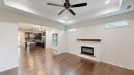 Located at 100 Foxborough Way in Richmond, Kentucky, this well-designed single-story home offers three bedrooms and two bathrooms across a thoughtfully laid-out floor plan. Rich hardwood flooring flows throughout the home, creating a warm and cohesive aesthetic.

The living room serves as the centerpiece of the home, featuring a striking tray ceiling with crown molding, a ceiling fan, and a shiplap fireplace with a rustic wood mantel. Clerestory windows allow natural light to filter in, enhancing the open, airy feel of the space.

The kitchen is a standout, equipped with dark espresso cabinetry, granite countertops, a central island with pendant lighting, a mosaic tile backsplash, and stainless steel appliances. The open sightline to the living area promotes a connected, functional layout ideal for everyday living and entertaining.

The primary bedroom is generously sized and includes a ceiling fan, large windows with wood blinds, and access to a walk-in closet outfitted with wire shelving. The two additional bedrooms also feature hardwood floors, ceiling fans, and ample natural light. Both bathrooms are clean and functional, with one featuring a tub/shower combo and gold-tone fixtures. A dedicated laundry room with cabinetry and a window completes the home's practical layout.