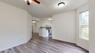 Located at 247 Marcliffe Dr in Valparaiso, Indiana, this single-story home offers a clean, modern interior with a thoughtfully designed open-concept layout. The bright living room features wood-look flooring, a ceiling fan, multiple windows that invite abundant natural light, and a fireplace framed by a classic white mantel — creating a warm and inviting focal point. The space flows seamlessly into the dining area and kitchen, which is equipped with white cabinetry, a tile backsplash, a gas range, refrigerator, built-in microwave, and a peninsula with counter seating. A French door in the kitchen provides convenient outdoor access. The bedrooms are carpeted for comfort, with ceiling fans and generous windows offering neighborhood views. The primary bedroom includes access to a spacious walk-in closet outfitted with wire shelving for organized storage, as well as a French door leading to the exterior. The bathroom features wood-look flooring, a vanity with cabinet storage, and a full bathtub and shower combination. A dedicated laundry room with a full-size washer and dryer adds everyday convenience. Throughout the home, a neutral color palette and consistent finishes create a cohesive and well-maintained living environment.
