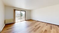 Located at 242 Amber Trl in Sun Prairie, Wisconsin, this 2-bedroom, 1-bathroom residence offers a practical and well-appointed single-floor layout. Throughout the space, light-toned wood-look flooring creates a cohesive and clean aesthetic, complemented by crisp white walls and dark-trimmed doors with gold hardware accents.

The living room is a comfortable, open area filled with natural light from a sliding glass door that leads directly to a private balcony, offering pleasant views of the surrounding neighborhood. Baseboard heating units are present throughout, ensuring efficient warmth across the residence. A ceiling fan in the living area adds to the comfort and airflow.

Both bedrooms are well-sized, each featuring windows that allow in natural light. The primary bedroom is notably spacious, providing ample room for furnishings. Dark-trimmed closet doors offer convenient storage in the bedroom areas.

The kitchen, visible from the main living space, features wood cabinetry and is efficiently laid out for everyday use. The full bathroom includes a tub/shower combination with tile surround, a toilet, tile flooring, and a vanity with warm wood cabinetry topped by a large mirror with overhead lighting. This residence offers a straightforward, functional design in a convenient Sun Prairie location.
