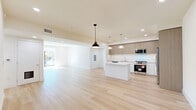 Located at 12078 Guerin St in Studio City, Los Angeles, this thoughtfully designed 2-bedroom, 2-bathroom home offers a bright, modern living experience across a single floor. Light-toned hardwood flooring flows seamlessly throughout, tying together a clean, contemporary aesthetic.

The open-concept living, dining, and kitchen area forms the heart of the home, bathed in natural light. Large sliding glass doors lead to a private balcony, offering sunny outdoor views of the surrounding neighborhood. The kitchen is a standout feature, equipped with stainless steel appliances including a gas range, built-in microwave, refrigerator with ice maker, and dishwasher. Two-tone cabinetry — warm wood uppers paired with crisp white lowers — frames a white tile backsplash, while a central island provides additional prep and storage space. Pendant lighting adds a stylish finishing touch overhead.

The primary bedroom is generously sized, filled with natural light, and features a sliding closet. The second bedroom is equally bright. Both bathrooms are finished with large-format tile flooring, sleek vanities, and tub-shower combinations with frameless glass enclosures. The primary bath includes an illuminated mirror and a warm wood vanity. Additional highlights include a dedicated laundry area, six closets for ample storage, and two hallways connecting the layout efficiently.