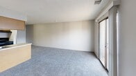 Located at 2707 S Emporia St in Wichita, Kansas, this one-bedroom, one-bathroom unit offers a practical and well-organized single-floor layout. The combined kitchen and living area forms the heart of the unit, with plush wall-to-wall carpeting throughout the living space and hard surface flooring in the kitchen. The kitchen features warm wood-toned cabinetry, a black appliance package including a refrigerator and range, a built-in dishwasher, and a peninsula with a sink that opens toward the living area — ideal for everyday functionality. The living room is bright and open, benefiting from a sliding glass door that leads to a private balcony overlooking a landscaped outdoor setting. The bedroom offers a comfortable, carpeted retreat with two side-by-side closets providing generous storage and a window allowing natural light to filter in. The bathroom includes a full tub and shower combination with clean white surround and chrome fixtures. An in-unit laundry area adds everyday convenience. Textured ceilings are consistent throughout, and neutral wall tones keep the space feeling clean and versatile. This unit delivers a functional layout with essential amenities in a residential Wichita location.