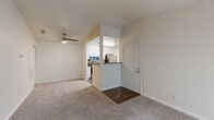 Located at 7541 Romona Ln in Citrus Heights, CA, this one-bedroom, one-bathroom residence offers a well-organized, efficient layout across a single floor. The living room serves as the heart of the home, featuring plush carpeting, a classic tile-surround fireplace, and a sliding glass door flanked by vertical blinds that opens to a private balcony with lush greenery views. A ceiling fan overhead adds comfort to the space. The entry transitions seamlessly between wood-look vinyl flooring near the front door and carpeted living areas. The kitchen is open and functional, outfitted with white cabinetry, dark countertops, stainless steel appliances including a refrigerator, range, and microwave, plus a single-basin sink with a window for natural light. The bedroom features vaulted ceilings, soft carpeting, and a bright window with blinds, creating a calm and airy retreat. It connects to a generously sized walk-in closet with wire shelving. The bathroom includes wood-look vinyl flooring, a white vanity with dark countertop, and a full bathtub. An in-unit laundry area adds everyday convenience, rounding out this practical and comfortable Citrus Heights residence.