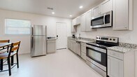 Located at 640 Rouge Bluff Road in Memphis, TN, this single-story 2-bedroom, 1-bathroom home offers a clean, minimalist design with a practical and well-organized layout. The interior is finished in crisp white throughout, creating a bright and cohesive aesthetic across all rooms.

The open living area features recessed lighting, light-toned floors, and a front entry door with a modern smart lock. Natural light filters in through several windows, enhancing the airy feel of the space. The living room provides a comfortable area for relaxing, while an adjacent dining area accommodates a four-seat dining set beneath a ceiling light fixture.

The kitchen is well-appointed with white shaker-style cabinetry, granite-patterned countertops, and a full suite of stainless steel appliances including a refrigerator, electric range, microwave, and dishwasher. Recessed lighting illuminates the galley-style layout efficiently.

Both bedrooms are modestly sized and feature white walls, light floors, and windows that bring in natural light. Each room offers a calm and restful atmosphere with a simple, functional design.

The bathroom includes a white vanity with granite-style countertop, a tub/shower combination, and a window for natural ventilation. A closet provides additional storage. The home's consistent clean finishes and efficient use of space make it a practical and comfortable residence.
