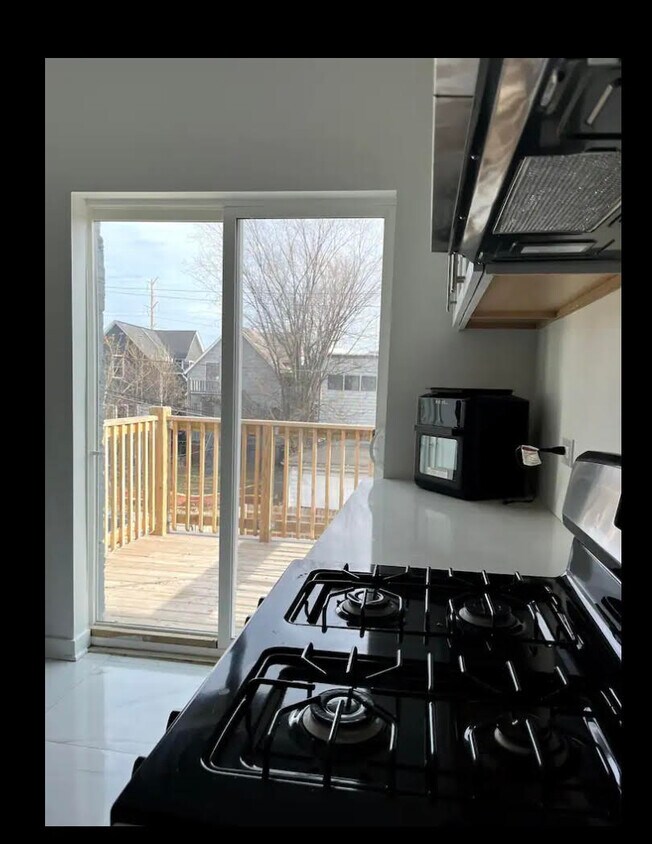 Cocina y vista al patio con puerta corrediza. La cocina incluye freidora de aire, electrodomésticos de cocina básicos - 7017 S Eberhart Ave