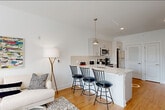 Located at 125 Main St in Lincoln Park, NJ, this 2-bedroom, 1-bathroom residence offers a thoughtfully designed single-floor layout with a clean, modern aesthetic. The open-concept living, dining, and kitchen area forms the heart of the home, featuring warm hardwood flooring, crisp white walls, and abundant natural light from large windows. The kitchen is well-appointed with white shaker-style cabinetry, a subway tile backsplash, light stone countertops, stainless steel appliances including a dishwasher, range, microwave, and refrigerator, and a peninsula with bar seating — ideal for casual dining. The living area offers a comfortable, bright atmosphere with natural light streaming in. The primary bedroom is a serene retreat highlighted by a striking arched window with garden views. The second bedroom is equally well-lit and includes a double closet for ample storage. The bathroom features light tile flooring and a clean, minimal design with accessibility-friendly grab bars. Three closets provide generous storage throughout, and a dedicated laundry area and utility room add everyday convenience. The consistent hardwood flooring and neutral palette tie the entire space together cohesively.