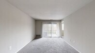 Located at 11 Cinnamon Cir in Randallstown, MD, this single-floor residence offers three bedrooms, one bathroom, a kitchen, and two hallways within a practical and well-organized layout. The living area features plush wall-to-wall carpeting and a full-width sliding glass door dressed with vertical blinds, allowing natural light to fill the space while providing direct access to the outdoors. The spacious primary bedroom includes a generous walk-in closet with built-in shelving, offering ample storage, and is finished with soft carpeting throughout. The additional bedrooms are similarly carpeted, with one featuring a standard closet with a bi-fold door and another benefiting from a bright window that invites natural light. The kitchen is equipped with warm oak cabinetry, dark laminate countertops, wood-look vinyl flooring, a white refrigerator, dishwasher, and stove, providing all the essentials for everyday cooking. The full bathroom features clean white tile surrounding a bathtub and shower combination, maintaining a simple and functional aesthetic. Neutral gray walls and white trim run consistently throughout the home, creating a clean, cohesive look. Two hallways connect the rooms efficiently, contributing to the home's straightforward and accessible flow.