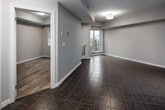 Located at 5 Rittenhouse Rd, Unit 310 in Kitchener, Ontario, this one-bedroom, one-bathroom unit offers an efficient and well-designed layout across a single floor. The open living area features neutral-toned walls, tile flooring, and a flush-mount ceiling light, creating a clean and bright atmosphere. A door leads to a private balcony, allowing for natural light and outdoor access directly from the main living space.

The kitchen is a standout feature, outfitted with rich dark-wood cabinetry, granite-look countertops, a double stainless steel sink, and a full suite of stainless steel appliances including a refrigerator, electric range, over-the-range microwave, and dishwasher. A decorative mosaic tile backsplash in grey and blue tones adds a modern touch to the space.

The bedroom offers a cozy and practical layout with wood-look vinyl flooring, neutral walls with clean white baseboards, and a set of double panel closet doors providing ample storage. The bathroom includes a full-sized soaker tub and shower combination with crisp white surrounds, maintaining the unit's clean and functional aesthetic throughout. This unit is a practical choice for those seeking comfortable, low-maintenance living in Kitchener.