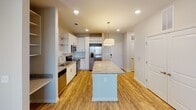 Located on Sommers Lane in Fort Mill, South Carolina, this single-floor residence offers a thoughtfully designed layout with a clean, contemporary aesthetic throughout. The open-concept kitchen serves as a central highlight, showcasing white shaker-style cabinetry, granite countertops, a full suite of stainless steel appliances including a range, microwave, and French door refrigerator, and a large center island with pendant lighting — ideal for both meal preparation and casual dining. Light wood-style flooring runs through the kitchen and living areas, adding warmth and visual continuity. The living room is generously sized, featuring a ceiling fan with light fixture, large windows dressed with horizontal blinds, and abundant natural light that creates a bright, welcoming atmosphere. Bedrooms are finished with plush wall-to-wall carpet, neutral-toned walls, and ceiling fans, with windows offering outdoor views. The bathroom is well-appointed with wood-look flooring, a granite-topped vanity, a full soaking tub with shower, and recessed lighting, complemented by clean white fixtures and ample storage. Throughout the space, white panel doors, clean baseboards, and a neutral color palette contribute to a cohesive, move-in-ready environment.