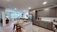 Located at 19025 Stuebner Airline Road in Spring, TX, this one-bedroom, one-bathroom unit offers a thoughtfully designed layout that maximizes functionality. Light wood-look flooring flows throughout the entire space, creating a cohesive and modern aesthetic.

The open-concept kitchen and living area serves as the heart of the unit. The kitchen features dark taupe cabinetry, granite countertops, subway tile backsplash, and stainless steel appliances, including a refrigerator, microwave, and range. A center island with a built-in sink and seating for two provides an ideal space for dining or casual use. The living area receives natural light through large windows fitted with blinds and is equipped with a ceiling fan.

An in-unit laundry area is conveniently tucked behind double doors, housing a full-size washer and dryer.

The bedroom is a comfortable, well-lit retreat with a ceiling fan, large window, and direct access to the bathroom. The bathroom offers a granite-topped vanity with dark cabinetry, a tub-shower combination with subway tile surround, and brushed nickel fixtures. A walk-in closet with wire shelving systems provides ample organized storage.