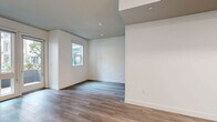 Located on El Cajon Blvd in San Diego's vibrant North Park neighborhood, this thoughtfully designed studio unit offers an efficient and modern single-floor layout. The open-concept living, dining, and kitchen area forms the heart of the space, finished with warm wood-tone luxury vinyl plank flooring and crisp white walls that maximize brightness. Recessed lighting throughout adds a clean, contemporary feel.

The kitchen is a standout feature, outfitted with sleek grey flat-front cabinetry extending floor to ceiling, white subway tile backsplash with under-cabinet lighting, light quartz countertops, and a full suite of stainless steel appliances including a gas range, dishwasher, microwave, and refrigerator. The living area is open and airy, with a large window bringing in natural light.

The bathroom is finished with large-format white wall tiles, a glass-enclosed walk-in shower with grey accent tile detailing, and matching wood-look flooring. A dedicated laundry area and a closet provide practical storage solutions. A hallway connects the rooms with ease.

The private patio opens to a landscaped courtyard within a modern multi-story building, offering a tranquil outdoor retreat with lush greenery and a contemporary architectural backdrop.