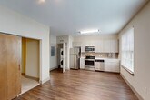 Located at 611 O'Keefe Ave in New Orleans, Louisiana, this well-designed one-bedroom, one-bathroom unit offers a smart and functional layout across a single floor. The open kitchen serves as the heart of the space, outfitted with stainless steel appliances including a refrigerator, range, microwave, and dishwasher, complemented by light wood-toned cabinetry, white countertops, and a subtle tile backsplash. A large window floods the kitchen and dining area with natural light, enhancing the warm hardwood-style flooring that flows throughout the main living areas. A stacked in-unit washer and dryer adds everyday convenience. A hallway connects the main living area to the private bedroom, which features plush carpet, a ceiling fan, and a mirrored sliding closet door offering ample storage. A barn-style wood sliding door adds a distinctive design touch. The bathroom is clean and well-appointed, featuring a full tub and shower combination with classic white subway tile surround and brushed nickel fixtures. Neutral tones throughout create a calm, cohesive ambiance, making this a practical and comfortable space in the heart of New Orleans.