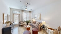 Located at 4245 Bobtown Rd in Garland, TX, this thoughtfully designed 1-bedroom, 1-bathroom residence offers a clean, modern aesthetic throughout its efficiently organized single-floor layout. The open-concept living, dining, and kitchen area serves as the heart of the home, bathed in natural light from large windows dressed with sheer linen curtains. A ceiling fan adds comfort to the inviting living space, which flows seamlessly onto a private patio — ideal for enjoying the outdoors. The kitchen is a standout, featuring crisp white shaker cabinetry with matte black hardware, a neutral tile backsplash, white quartz countertops, stainless steel appliances, and a large farmhouse-style sink set into a central island illuminated by pendant lighting. Light wood-tone flooring runs throughout, enhancing the bright, airy feel of the space. The bedroom is generously proportioned, offering multiple windows for abundant natural light and a ceiling fan overhead. The hallway connects two closets, a dedicated laundry area, a utility room, and a pantry — providing excellent storage. The bathroom features a clean white vanity, a framed mirror, and a glass-enclosed shower, maintaining the home's consistent modern style.