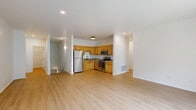 Located at 2 Riverchase Dr in Rensselaer, NY, this two-bedroom, two-bathroom home spans two floors and offers a well-organized, functional layout. The main living level hosts an open-concept kitchen and living room area finished with light hardwood-style flooring throughout. The living room is bright and airy, featuring a classic fireplace and sliding glass doors that open onto a balcony with outdoor views, allowing natural light to fill the space. The kitchen is efficiently designed with warm honey-toned wood cabinetry, stainless steel appliances including a refrigerator, range, microwave, and dishwasher, and ample counter space with a stainless steel sink. Both bedrooms are carpeted in neutral tones, providing a comfortable and quiet retreat. The generously sized primary bedroom offers considerable floor space and convenient closet access. Six closets throughout the home ensure abundant storage. The two bathrooms include a walk-in shower with brushed nickel fixtures and hardwood-style flooring. A dedicated laundry area and an attached garage with an automatic opener add everyday practicality. The clean white walls, recessed lighting, and consistent flooring choices throughout create a cohesive, move-in-ready atmosphere.