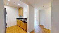 Located on Santa Monica Boulevard in the heart of Santa Monica, CA, this well-appointed one-bedroom, two-bathroom residence offers a thoughtfully designed single-floor layout with a bright, open feel throughout. Light hardwood flooring runs continuously through the living areas and bedroom, creating a warm, cohesive aesthetic against crisp white walls.

The kitchen is outfitted with light maple cabinetry, dark granite countertops, stainless steel appliances including a gas range, microwave, refrigerator, and dishwasher. It opens toward the living room via a half-wall pass-through, enhancing the sense of connectivity and flow.

The spacious living room receives abundant natural light through floor-to-ceiling windows and sliding glass doors that lead to both a balcony and a patio, offering views of the surrounding Santa Monica cityscape.

The generously sized primary bedroom features large windows with urban views, a mirrored sliding closet, and direct access to additional storage. Both bathrooms are finished with classic white subway tile surrounds, soaking tubs with shower combinations, and warm-toned hardware. Three closets throughout the residence provide ample storage. Clean lines, neutral tones, and plentiful natural light define the overall ambiance of this urban Santa Monica residence.