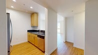 Located on Santa Monica Boulevard in the heart of Santa Monica, CA, this well-appointed one-bedroom, two-bathroom residence offers a thoughtfully designed single-floor layout with a bright, open feel throughout. Light hardwood flooring runs continuously through the living areas and bedroom, creating a warm, cohesive aesthetic against crisp white walls.

The kitchen is outfitted with light maple cabinetry, dark granite countertops, stainless steel appliances including a gas range, microwave, refrigerator, and dishwasher. It opens toward the living room via a half-wall pass-through, enhancing the sense of connectivity and flow.

The spacious living room receives abundant natural light through floor-to-ceiling windows and sliding glass doors that lead to both a balcony and a patio, offering views of the surrounding Santa Monica cityscape.

The generously sized primary bedroom features large windows with urban views, a mirrored sliding closet, and direct access to additional storage. Both bathrooms are finished with classic white subway tile surrounds, soaking tubs with shower combinations, and warm-toned hardware. Three closets throughout the residence provide ample storage. Clean lines, neutral tones, and plentiful natural light define the overall ambiance of this urban Santa Monica residence.