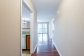 This single-floor residence offers a thoughtfully designed layout with a warm, neutral color palette that creates a welcoming ambiance throughout. A central hallway with rich hardwood flooring connects the main living areas, drawing the eye toward a bright, window-lined living space at its end, where vertical blinds filter abundant natural light.

The open-concept kitchen is equipped with warm-toned wood cabinetry, granite countertops, and stainless steel appliances, including a smooth-top range with over-the-range microwave and a refrigerator. A peninsula counter separates the kitchen from the adjoining living area, which continues the hardwood flooring and offers a bright, open feel.

The bedrooms are carpeted and painted in soft, neutral tones. The largest bedroom benefits from multiple windows and a sliding glass door with vertical blinds, allowing generous natural light. Additional bedrooms each feature windows with views of outdoor greenery. Closet access is provided throughout the bedroom areas.

The bathrooms are finished with tile flooring and wood vanity cabinetry. One bathroom includes a well-lit vanity mirror with overhead lighting, a tub-shower combination, and classic fixtures, while a second bathroom mirrors this practical, clean design. Overall, the space presents a functional and comfortable layout suitable for everyday living.