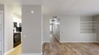 This well-appointed 2-bedroom, 2-bathroom single-floor unit offers a functional and cohesive layout designed for comfortable everyday living. Throughout the main living areas and hallways, durable wood-look plank flooring lends a warm, contemporary feel, while neutral gray walls create a clean, versatile backdrop.

The open living room is a welcoming space featuring built-in wall shelving and a pass-through view into the kitchen, enhancing the sense of openness. The kitchen is equipped with white shaker-style cabinetry, sleek quartz countertops, stainless steel appliances including a refrigerator, and a dishwasher — offering both style and practicality.

Both bedrooms are carpeted for added comfort and include ceiling fans with light fixtures. Each bedroom benefits from natural light provided by windows with vertical blinds. The primary bedroom is a well-sized retreat with access to a dedicated closet.

The two bathrooms mirror each other in design, each featuring a tub/shower combination with white tile surround, quartz-topped vanities with white cabinetry, and the same wood-look flooring found throughout the unit.

Two closets provide ample storage, and the unit's efficient layout ensures every area is purposefully utilized. The overall ambiance is bright, clean, and move-in ready.