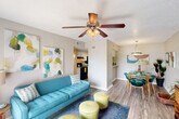 Located at 811 Harvey Rd in College Station, TX, this single-floor unit offers a functional and comfortable layout across two bedrooms, one bathroom, and a thoughtfully organized set of living spaces. The living room is bright and welcoming, featuring a ceiling fan, wood-look flooring, and large sliding glass doors fitted with vertical blinds that let in generous natural light and provide outdoor views. Adjacent to the living area, the dining room is illuminated by a pendant light fixture and sits conveniently near a dedicated laundry nook. The galley-style kitchen is efficiently designed with white cabinetry, light countertops, wood-look flooring, and black appliances including a range and refrigerator. The primary bedroom is a comfortable retreat with carpet flooring, a ceiling fan, a window with outdoor views, and direct access to a dedicated closet. The second bedroom is similarly appointed. The bathroom features a shower-tub combo with a curtain rod, wood-look flooring, a white vanity with a light countertop, and a large mirror. Two closets throughout the unit provide practical storage solutions. Textured walls are consistent throughout, contributing to the space's cohesive character.