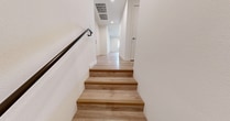 This contemporary residence in Murrieta, California offers 2030 square feet of living space spread across two floors. The home features three bedrooms, including a generous 210 square foot primary suite, and two full bathrooms. The main level encompasses 1670 square feet, while the lower level adds 370 square feet.

The interior is characterized by a bright, open concept design with modern finishes throughout. Light wood-look flooring unifies the space, complemented by crisp white walls and recessed lighting. The kitchen is a standout feature, boasting two-tone cabinetry in rich wood tones, stainless steel appliances, and ample counter space with a central island.

Bedrooms are spacious and well-lit, with large windows allowing natural light to flood in. Closet space is plentiful, with at least one walk-in closet visible in the images. Bathrooms maintain the modern aesthetic with sleek fixtures and wood vanities.

The home's layout includes a combined kitchen and living room area, perfect for entertaining. Multiple staircases throughout the property ensure easy navigation between floors. Additional amenities include a garage with an automatic door opener and built-in storage solutions.

Overall, this property presents a harmonious blend of style and functionality, ideal for contemporary living in Southern California.