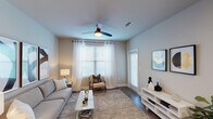 This single-floor residence offers a thoughtfully designed layout that maximizes functionality and style across one bedroom and one bathroom. The living area is bright and welcoming, featuring wood-style flooring, a ceiling fan, and large windows dressed with sheer white curtains and blinds that flood the space with natural light. The open-concept kitchen is a standout, showcasing granite countertops, dark espresso cabinetry, stainless steel appliances—including a range, microwave, and refrigerator—and a generous kitchen island with an undermount sink, ideal for both cooking and casual dining. Recessed lighting and tile backsplash add a refined touch to the culinary space. The bedroom is a serene retreat, featuring the same wood-style flooring, a ceiling fan, and large windows that continue the home's bright, airy aesthetic. The bathroom connects seamlessly to the bedroom and offers a granite-topped vanity with dark cabinetry, a single undermount sink, and a well-lit mirror. Generous storage is provided through multiple closets accessible from the hallway. Throughout the residence, neutral wall tones, clean architectural lines, and consistent high-quality finishes create a cohesive and modern living environment.