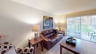 This single-floor residence offers a well-organized layout with distinct living spaces that flow naturally from one to the next. The living room is carpeted and features a sliding glass door fitted with vertical blinds, providing direct access to an outdoor patio and allowing natural light to fill the room. Adjacent to the living area, the dining room showcases warm hardwood flooring, a ceiling fan, and easy access to the kitchen, making it practical for everyday use.

The kitchen is efficiently designed with light wood cabinetry, laminate countertops, and hardwood-style flooring. A window above a small bistro-style eat-in nook brings in additional natural light, enhancing the room's functionality.

The primary bedroom is carpeted and includes a sliding glass door to the patio, offering an outdoor connection. It is well-appointed with ample space for a dresser and nightstands. The second bedroom, also carpeted, features a window with blinds that admits natural light.

Two bathrooms serve the residence. One includes a single-sink vanity with wood cabinetry and a separate water closet with a tiled tub-shower combination. The second bathroom features a fully tiled walk-in shower with hardwood-style flooring, providing a clean and functional design.