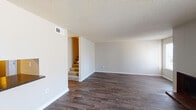 This two-story, 3-bedroom, 2.5-bathroom home is thoughtfully designed to maximize functionality across its well-proportioned floor plan. The main level features dark hardwood-style flooring that extends through the living room, dining area, and kitchen, lending a cohesive and polished look throughout. The living room is a bright, open space with neutral-toned walls, a textured ceiling, and a carpeted staircase leading to the upper level. Adjacent to the living room, the dining area benefits from natural light through a window and connects seamlessly to the kitchen. The kitchen is equipped with ample white cabinetry, dark countertops, a double basin sink, dishwasher, and electric range, offering generous storage and prep space. A dedicated laundry area with hookups adds everyday convenience. Upstairs, the carpeted bedrooms provide a comfortable retreat. The primary bedroom includes a closet and an en-suite bathroom, while additional bedrooms are generously sized with access to natural light. The bathrooms feature terrazzo-style countertops, tub-shower combinations, and mirrored medicine cabinets. A half bath is available on the main level for guests. Throughout, the home maintains a clean, neutral palette that is versatile and move-in ready.