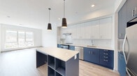 Located in Pittsburgh's South Side neighborhood, this modern 2-bedroom, 1-bathroom residence offers a thoughtfully designed open-concept layout. Light wood-tone flooring flows consistently throughout, complementing the clean white walls and creating a bright, cohesive aesthetic.

The kitchen is a standout feature, showcasing a two-tone cabinet design with bold navy lower cabinets and crisp white upper cabinets, accented by a white subway tile backsplash and sleek stainless steel appliances. A central island with open shelving and a white quartz countertop serves as both a prep space and a gathering point, while modern pendant lights add a stylish finishing touch.

The adjacent living area is open and airy, filled with natural light and offering seamless flow from the kitchen. The spacious primary bedroom features large windows that frame picturesque views of the Pittsburgh skyline and hillside, flooding the room with natural light. The second bedroom also benefits from generous window placement and direct access to the living space.

A well-appointed hallway connects the bedrooms to the full bathroom, which includes a vanity with ample storage. An additional closet provides practical storage for residents. The overall design reflects a clean, contemporary sensibility well-suited for modern urban living.