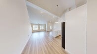 Located at 8 Arbutus Path in Mount Sinai, NY, this three-floor home offers a thoughtfully designed layout with 2 bedrooms, 2 bathrooms, and a versatile loft. The main level serves as the heart of the home, featuring a dramatic open-concept living, dining, and kitchen area beneath soaring vaulted ceilings. Light hardwood flooring flows throughout, enhancing the bright and airy ambiance created by recessed lighting and large windows. The kitchen is a standout, showcasing white shaker cabinetry, a marble-look tile backsplash, quartz countertops, stainless steel appliances, and a large center island topped with a stylish pendant light fixture. The bathrooms are finished with marble-look tile flooring, white vanities with quartz countertops, and black hardware accents, lending a clean and modern aesthetic. The generously sized primary bedroom includes access to sliding glass doors and receives ample natural light with outdoor views. The secondary bedroom features plush carpeting and a bright window. A loft level provides additional flexible space, while the dedicated laundry area and abundant closet storage — including six closets — add everyday practicality to this well-appointed home.