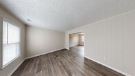 Located at 704 Windy Hill Dr in Fayetteville, NC, this two-story home offers a well-designed layout with a blend of practical finishes and modern updates throughout. The main living area welcomes you with rich, dark hardwood-style flooring and distinctive vertical shiplap-style wall paneling, lending a clean, contemporary character to the space. A staircase leads to the upper level, and a louvered-door closet provides convenient main-floor storage. The kitchen is a standout feature, showcasing crisp white shaker-style cabinetry, granite-look countertops, a classic white subway tile backsplash, and a stainless steel double-basin sink — a functional and attractive space for everyday use. The bedrooms are generously sized, finished with plush carpeting and ceiling fans for year-round comfort. One bedroom notably features dual closets, offering excellent storage capacity, along with a window that brings in natural light. The bathrooms are thoughtfully appointed, with one full bath featuring a tub-shower combination and wood-look flooring, and a half bath with a granite-topped vanity and a large mirror. Textured ceilings are consistent throughout the home, adding subtle architectural detail to every room.