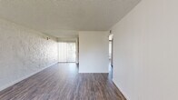 Located in Scottsdale, Arizona, this 2-bedroom, 2-bathroom single-floor unit offers a practical and well-organized layout. Wood-style flooring runs throughout the entire space, providing a cohesive look and easy maintenance. The living room is an open, airy area featuring textured accent walls, a textured ceiling, and a sliding glass door that invites natural light and outdoor access. The kitchen is efficiently designed with light wood cabinetry, ample upper and lower storage, a double-basin sink, and white appliances including a range, dishwasher, and refrigerator. Both bedrooms are comfortably sized with windows that bring in natural light; the primary bedroom includes a large closet with bifold doors, while the second bedroom offers a bright, neutral space. A dedicated walk-in closet provides additional built-in shelving for extra storage. The two bathrooms are cleanly finished — one features a shower stall with glass sliding doors and a single-sink vanity, while the second includes a full tub-shower combination with tiled surround and a matching vanity. Textured walls appear throughout, adding a subtle design element consistent with the Scottsdale aesthetic. The overall ambiance is clean, neutral, and move-in ready.